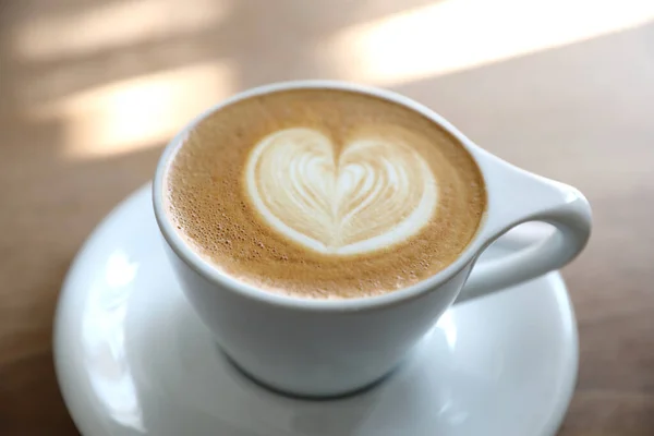 Café de arte cappuccino ou Latte feito de leite na mesa de madeira — Fotografia de Stock