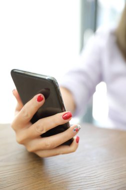 İş dünyasında akıllı telefon kullanan kadın eli