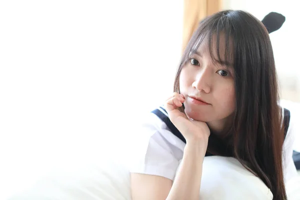 Portret japonez școală fată în alb ton pat cameră — Fotografie, imagine de stoc