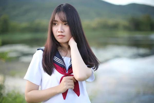 Retrato de asiático japonés escuela chica traje buscando en parque o — Foto de Stock