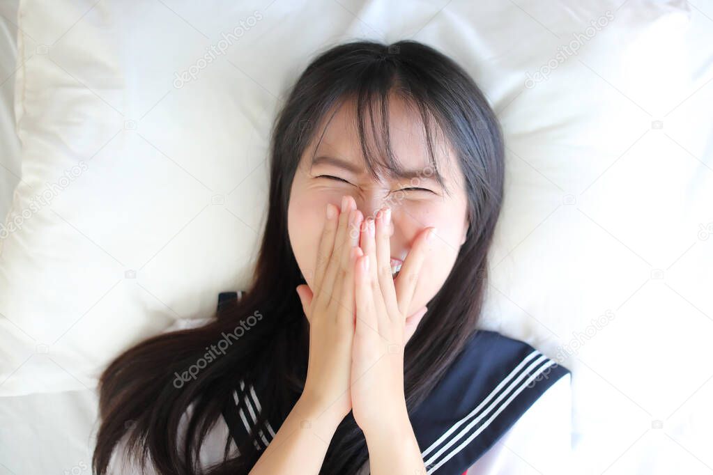 Portrait japanese school girl sleep and smile in white tone bed 