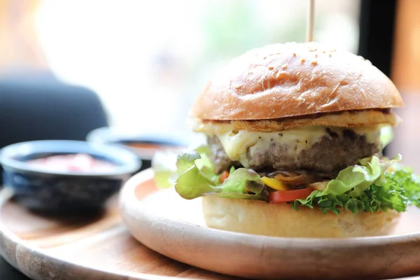 Hovězí hamburger se sýrově zeleným salátovým vejcem a omáčkou v restauraci — Stock fotografie