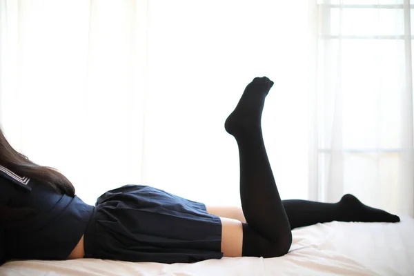 Portrét japonská škola dívka spací v bílém tónu postel pokoj — Stock fotografie
