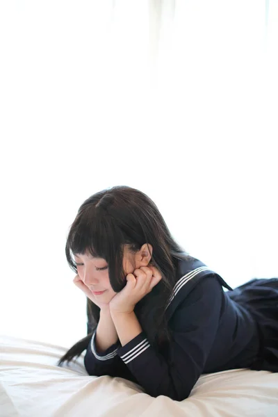 Portré japán iskolás lány alszik fehér tónusú szoba — Stock Fotó