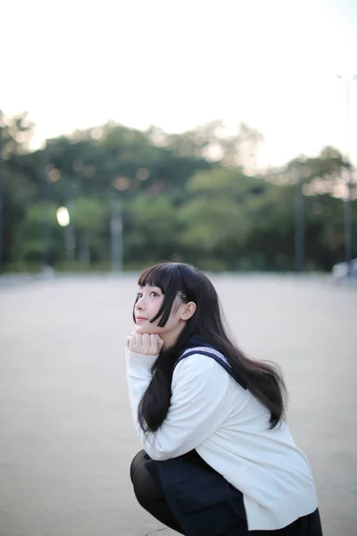 Asiatico scuola ragazza a piedi in urbano città con verde darden — Foto Stock