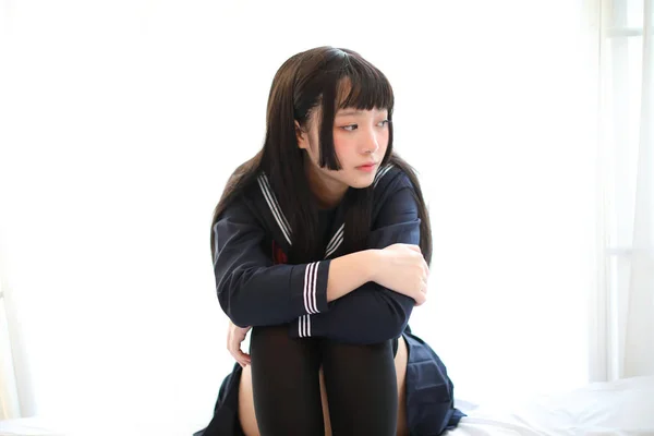 Retrato japonés escuela chica en blanco tono cama habitación — Foto de Stock
