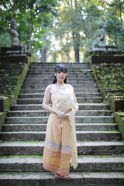 Portret tajskiej kobiety w tradycyjnej tajskiej sukience ze świątynią — Zdjęcie stockowe