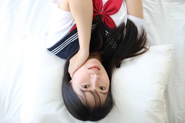 Beyaz tonlu yatak odasında Japon okul kızı portresi — Stok fotoğraf