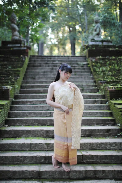 Porträt einer Thailänderin mit traditioneller thailändischer Kleidung mit Tempel — Stockfoto