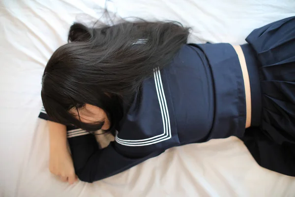 Portré japán iskolás lány alszik fehér tónusú szoba — Stock Fotó