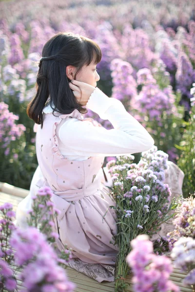 有紫色花朵背景的亚洲女孩的肖像 — 图库照片