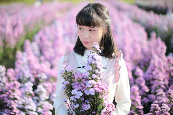 Портрет азіатської дівчини з фіолетовим квітковим тлом — стокове фото