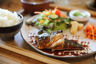 Saba balığı teriyaki, pirinç çorbası ve ahşap arka planda salata. ,