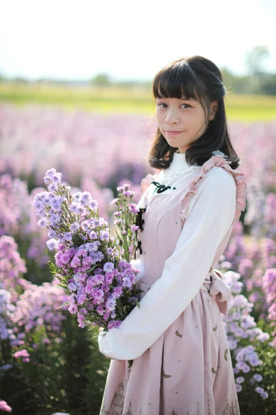 보라색 꽃 배경이 있는 인물상 아시아인 소녀 — 스톡 사진