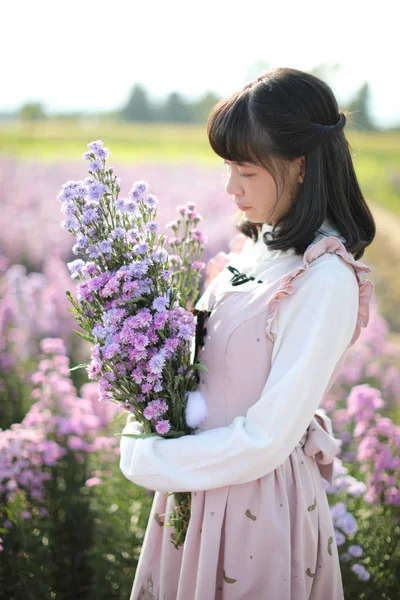 Portret azjatycki dziewczyna z purpurowe kwiaty tło — Zdjęcie stockowe