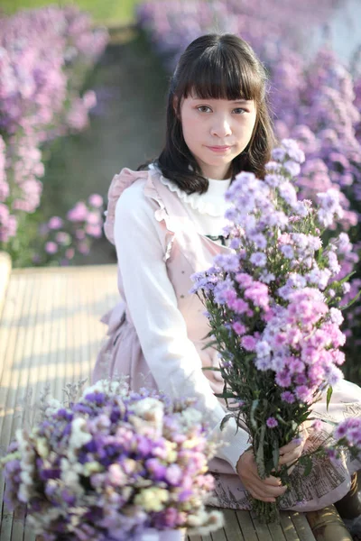 Retrato menina asiática com flores roxas fundo — Fotografia de Stock