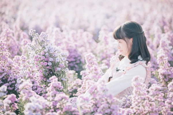 보라색 꽃 배경이 있는 인물상 아시아인 소녀 — 스톡 사진