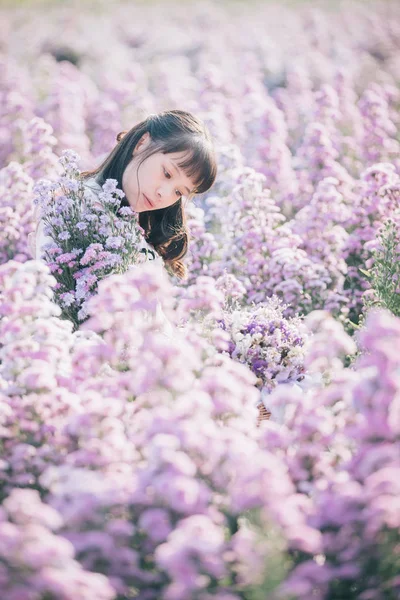 有紫色花朵背景的亚洲女孩的肖像 — 图库照片