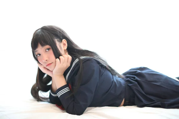 ポートレート日本語学校の女の子は白いトーンベッドルームで寝て — ストック写真
