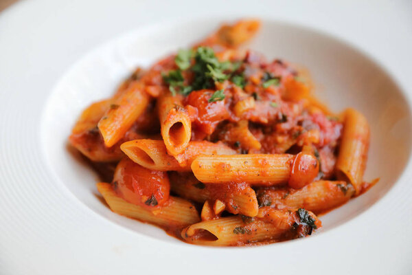 Penne arrabiata pasta tomato sauce with spices italian food on w