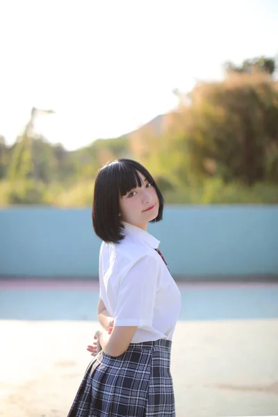 Πορτρέτο του κοριτσιού από την Ασία με λευκό πουκάμισο και φούστα κοιτάζοντας έξω — Φωτογραφία Αρχείου