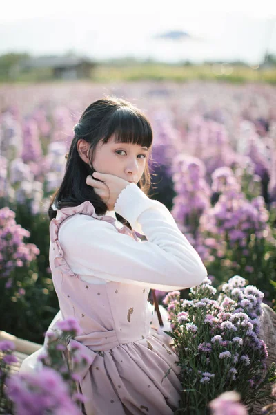 Retrato menina asiática com flores roxas fundo — Fotografia de Stock