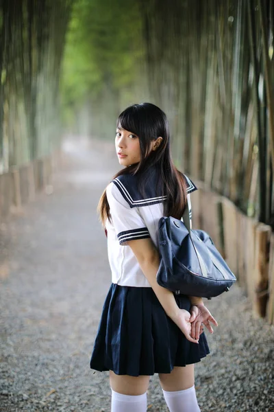 Retrato de traje asiático menina escola japonesa olhando em bambu — Fotografia de Stock