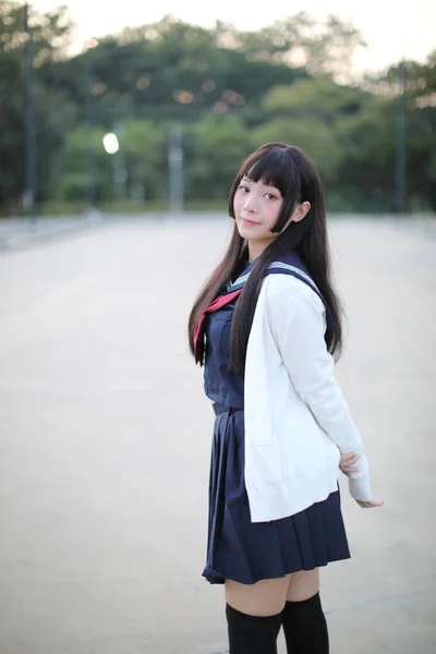 Asian school girl walking in urban city with green darden — Stock Photo, Image