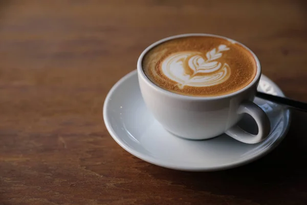 Capuchino o café de arte latte hecho de leche en la mesa de madera — Foto de Stock