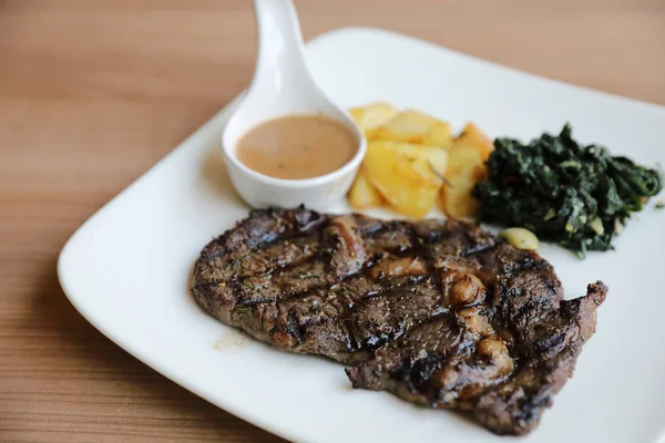 Beef steak with potato on wood background — Stock Photo, Image