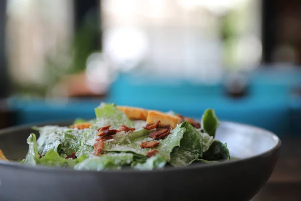 Caesar salade met knapperig brood en spek close up op hout backgr — Stockfoto