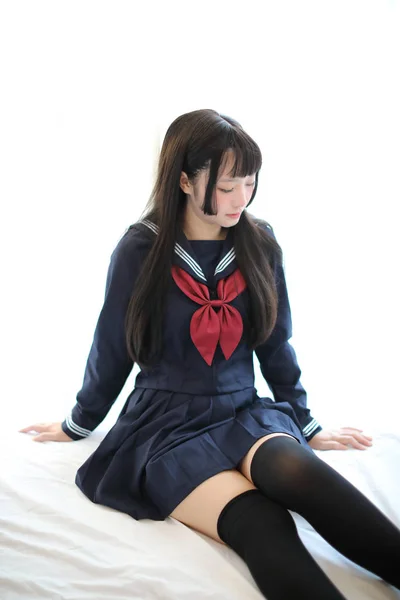 Portret japans schoolmeisje in wit toon slaapkamer — Stockfoto