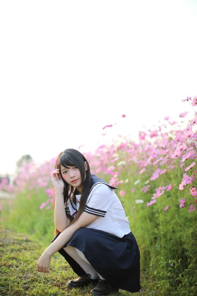 Retrato de uniforme de niña de escuela japonesa con flor de cosmos rosa —  Fotos de Stock