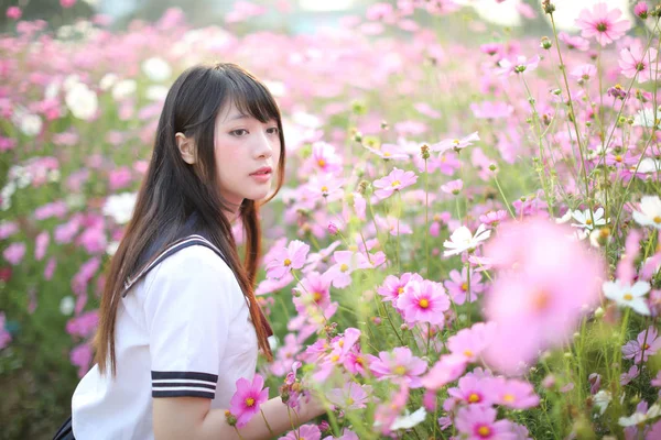 Portret japońskiej dziewczyny w mundurze z różowym kwiatem kosmosu — Zdjęcie stockowe