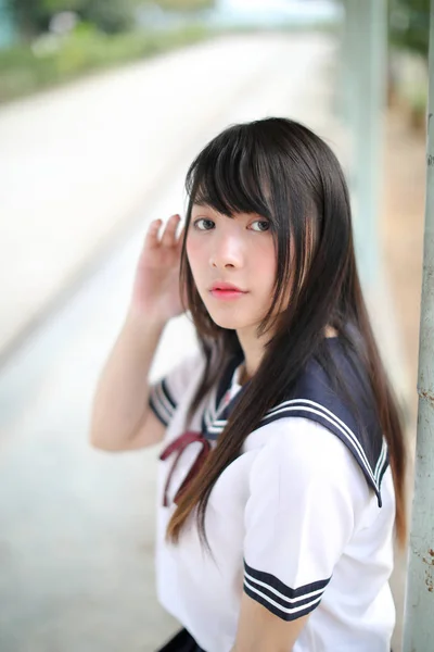 Asian school girl sitting with outdoor background — Stock Photo, Image