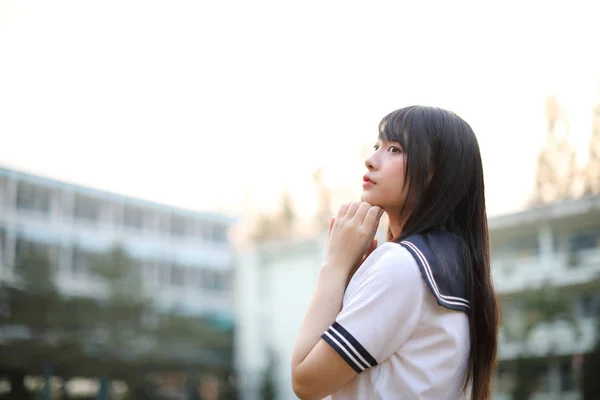 Asiática escuela chica sentado con al aire libre fondo —  Fotos de Stock