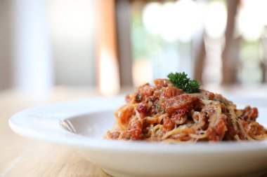 Parmesan peyniri ve fesleğenle süslenmiş kıyma ve domates soslu spagetti bolonez, İtalyan yemeği.