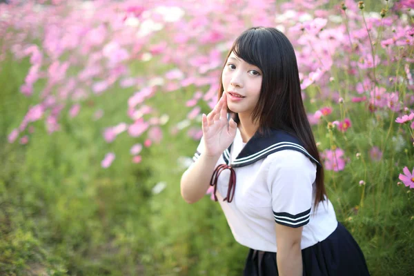 ピンクのコスモスの花で統一された日本の女子高生の肖像 — ストック写真