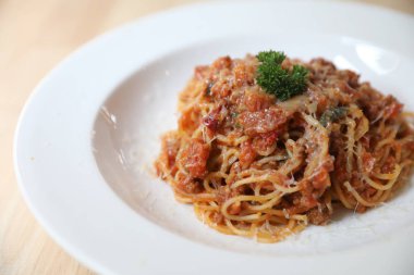 Parmesan peyniri ve fesleğenle süslenmiş kıyma ve domates soslu spagetti bolonez, İtalyan yemeği.