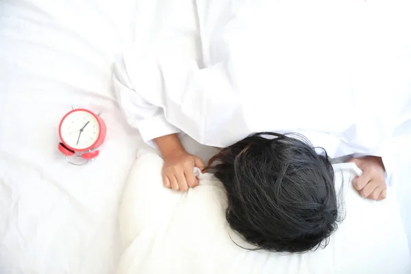 Азійка Ліниво Спить Прокидаючись Ліжку Годинником Білій Спальні — стокове фото