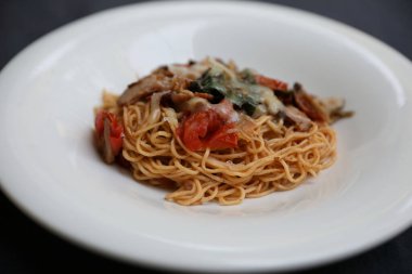 Parmesan peyniri ve fesleğenle süslenmiş kıyma ve domates soslu spagetti bolonez, İtalyan yemeği.