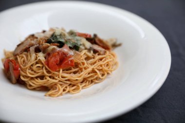 Parmesan peyniri ve fesleğenle süslenmiş kıyma ve domates soslu spagetti bolonez, İtalyan yemeği.