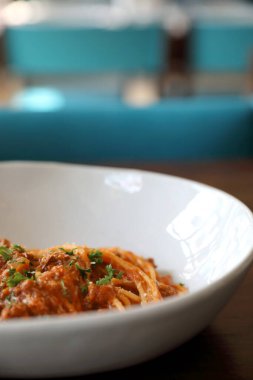 Parmesan peyniri ve fesleğenle süslenmiş kıyma ve domates soslu spagetti bolonez, İtalyan yemeği.