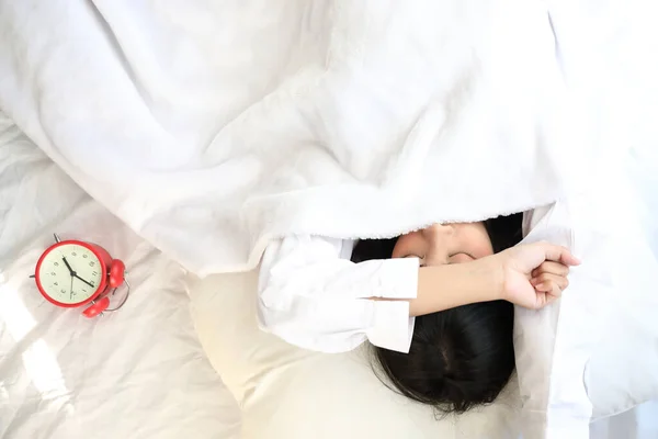 Азійка Ліниво Спить Прокидаючись Ліжку Годинником Білій Спальні — стокове фото