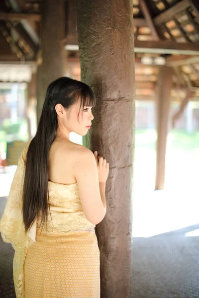 寺院を背景に伝統的なタイのドレスを持つタイの女性の肖像 — ストック写真