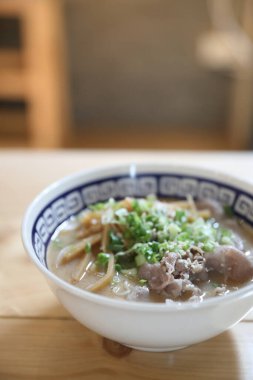 Ramen Japon eriştesi çorbası, erişte ve ahşap masada domuz eti.
