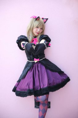 Japon animasyonu, pembe oda arka planında kız kostümü portresi.