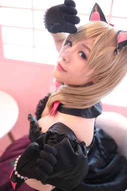 Japon animasyonu, pembe oda arka planında kız kostümü portresi.