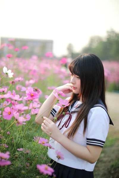 ピンクのコスモスの花で統一された日本の女子高生の肖像 — ストック写真