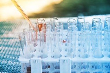 Laboratuvar bilim araştırma cam öğelerini damla birkaç test tüpleri birine ekleme. Bilimsel deneyde Bilim Araştırma Laboratuvarı.